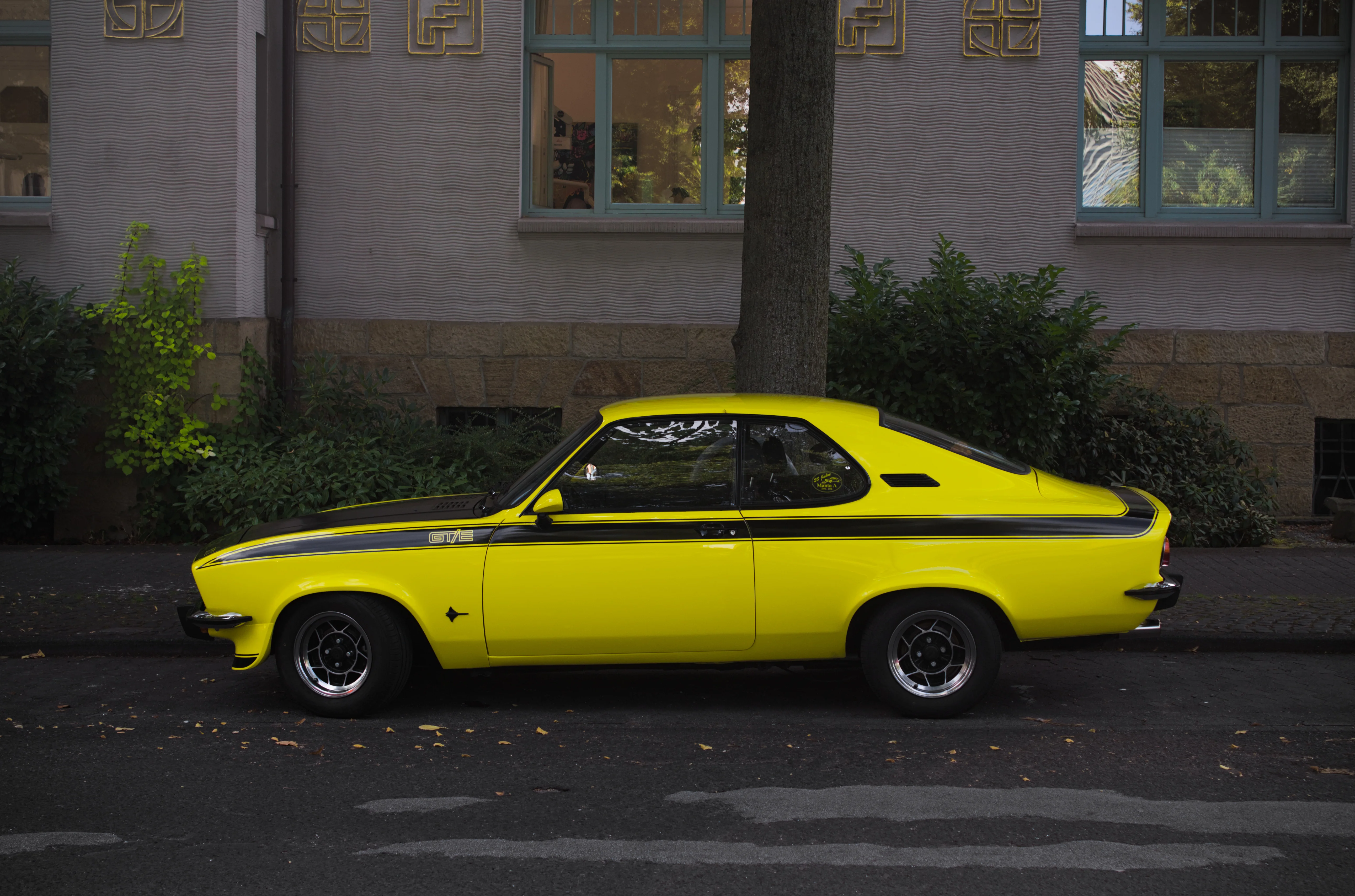 Das Bild eines gelben Opel Manta A, welche Seitwärts fotografiert wurde.